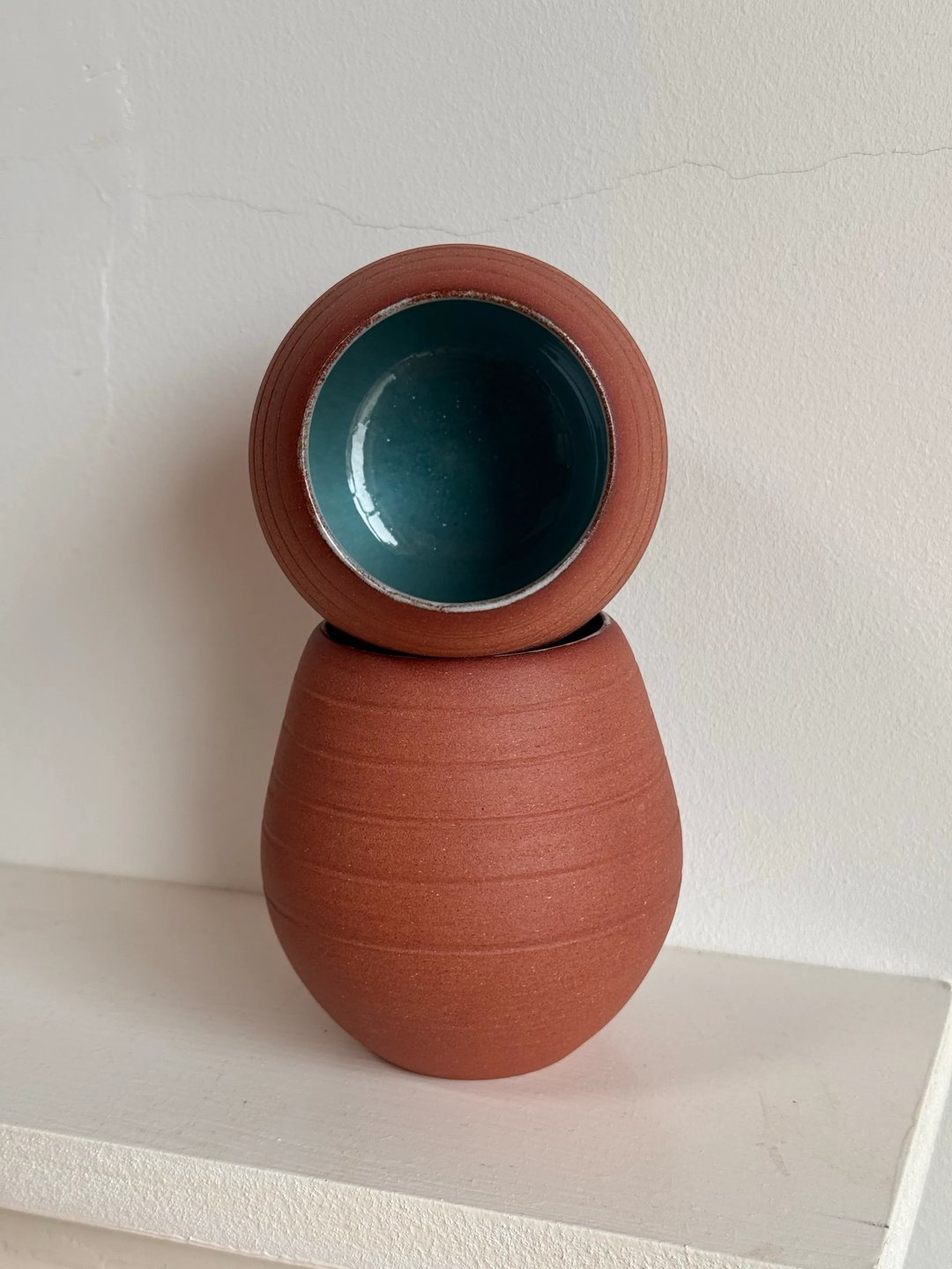Egg-shaped cups, unglazed red clay outside, pale turquoise inside, view 1