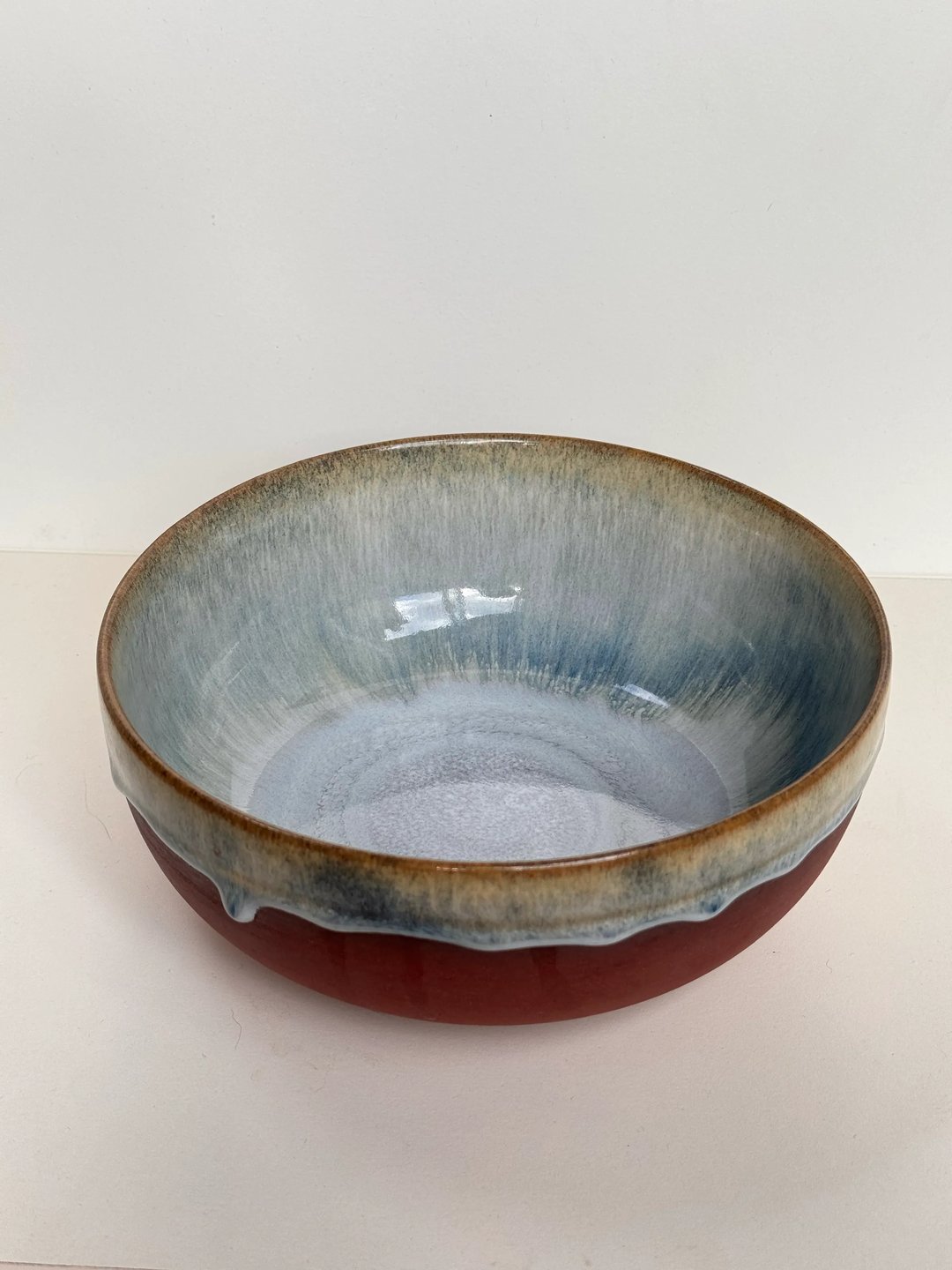 Large bowl with drippy glaze, unglazed red clay outside, misty blue inside, view 1